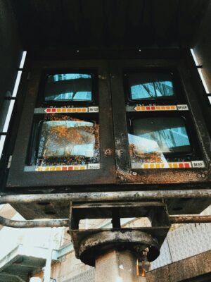 From below of rusty post with surveillance cameras installed on street at daylight