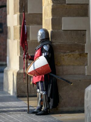 Man Wearing Gray and Red Armour Standing on the Streets