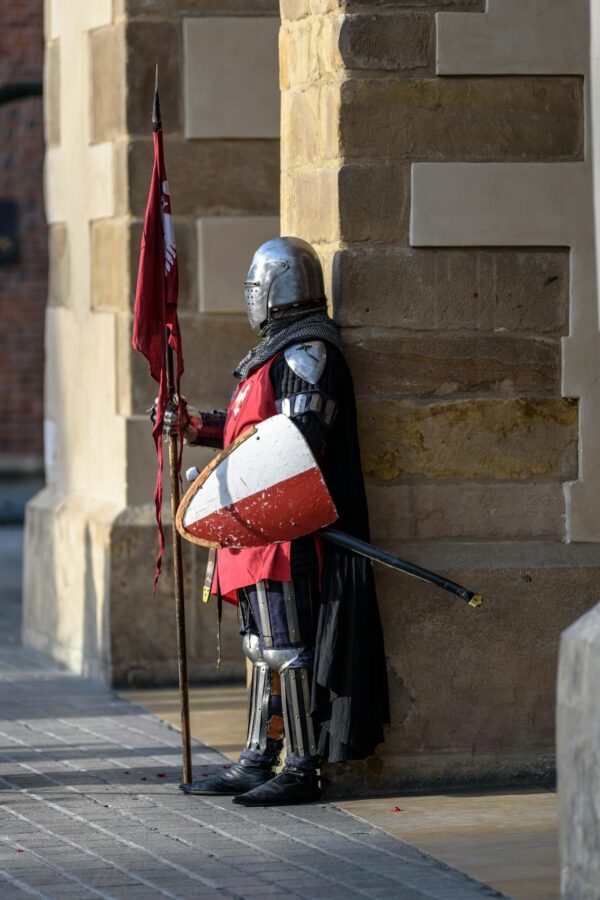 Man Wearing Gray and Red Armour Standing on the Streets