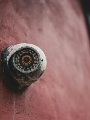 Old security camera on shabby building wall