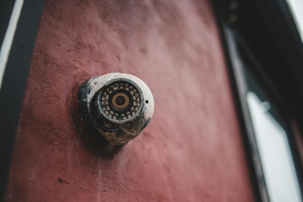 Old security camera on shabby building wall